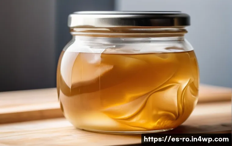 콤부차 가죽의 세척 및 보관 방법 - A close-up, highly detailed image of a healthy SCOBY floating in a wide-mouth glass jar filled with ...